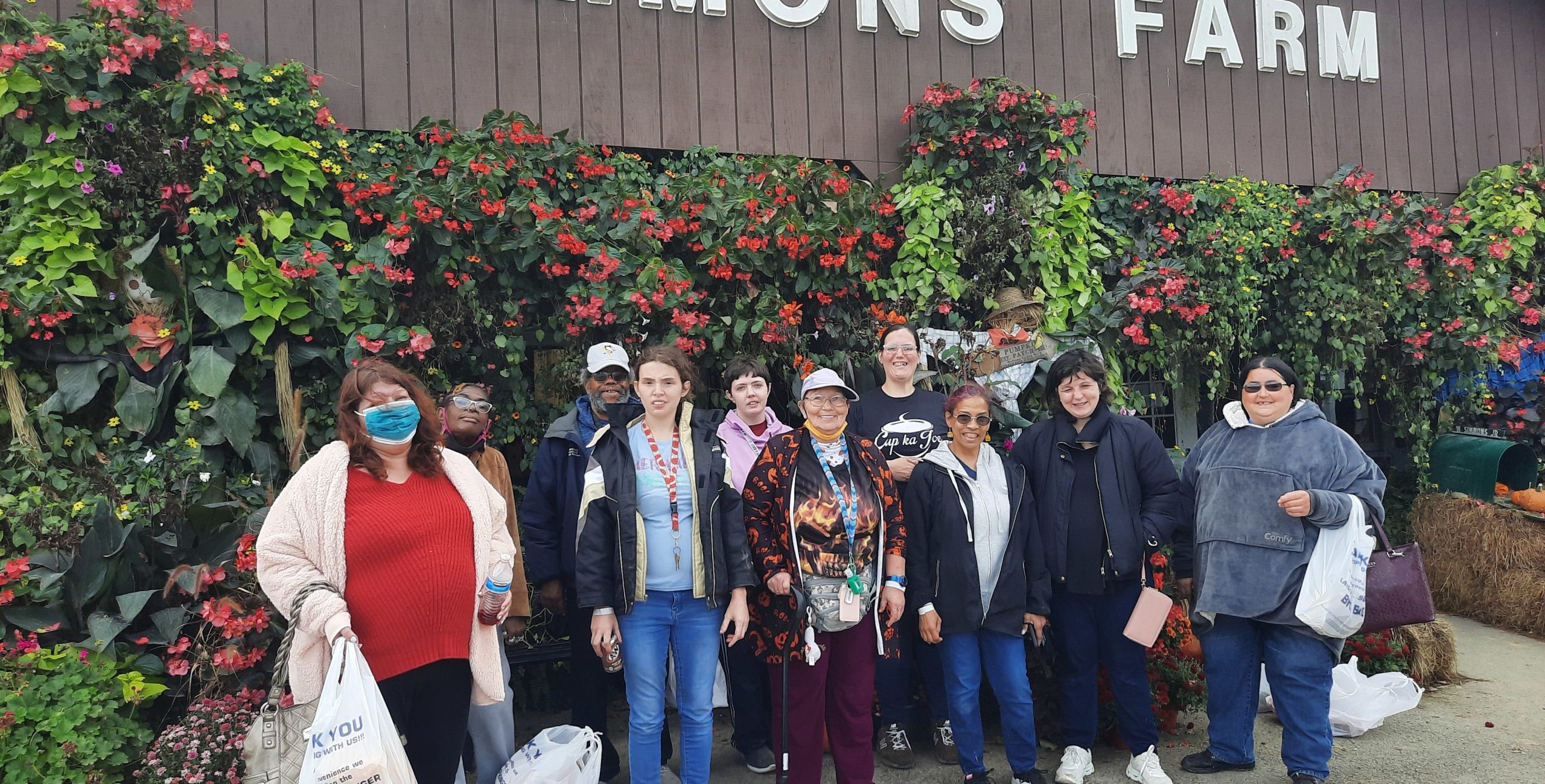 Members and staff posing in front of the Simmons Farm